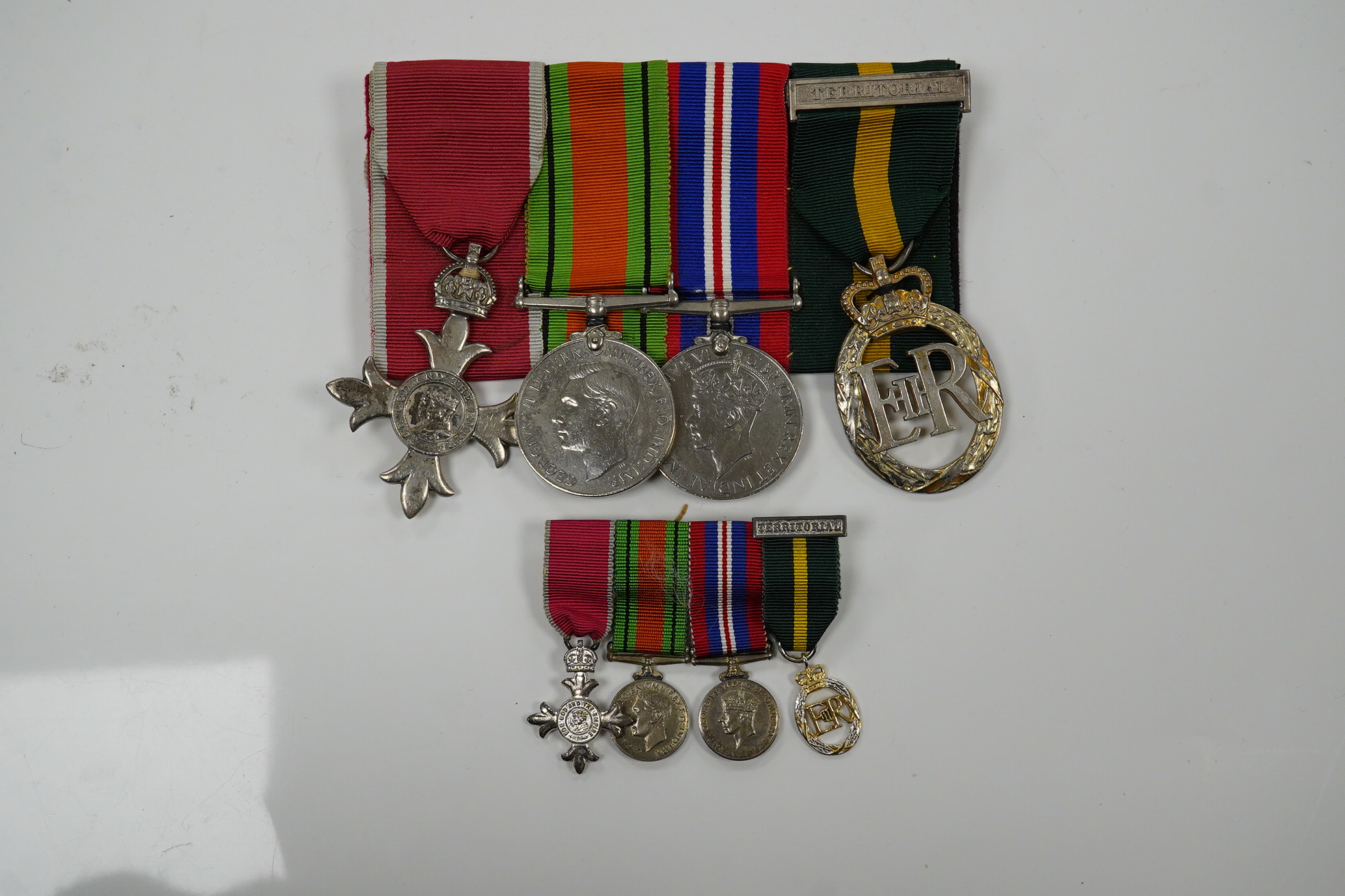 A group of 4 medals including MBE in display case